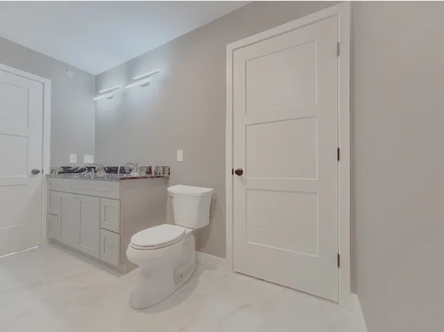 a white toilet sitting next to a bathroom sink