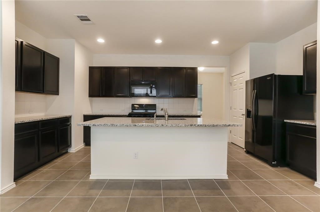 2233 Ringstaff Road Leander, TX 78641 - Photo 5 of 18 a kitchen with stainless steel appliances a refrigerator sink and microwave