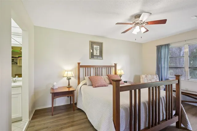 a bedroom with a bed dresser and a large window