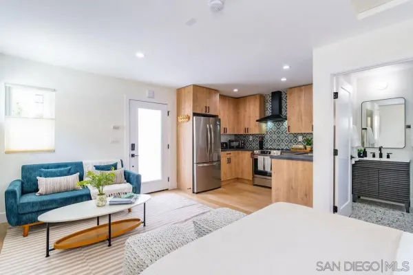 a large living room with stainless steel appliances kitchen island granite countertop furniture and a kitchen view