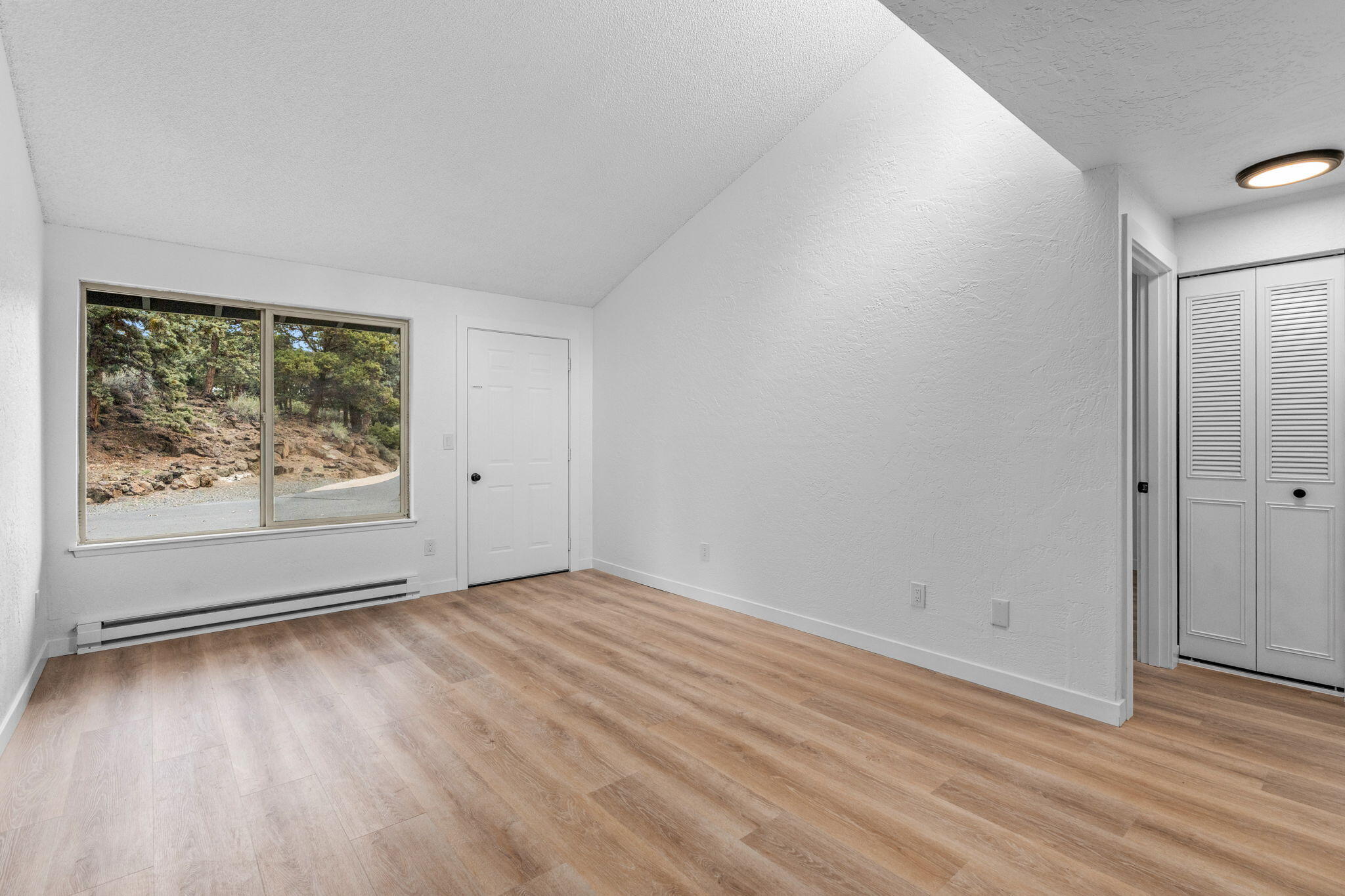 1700 Northeast Wells Acres Road, Unit 25 Bend, OR 97701 - Photo 10 of 25 wooden floor in an empty room with a window