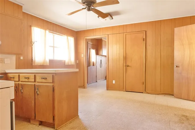 a view of a livingroom with a chandelier fan and wooden floor