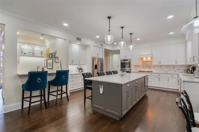 a kitchen with white cabinets and appliances
