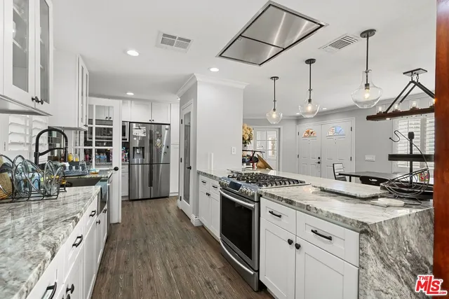 a kitchen with stainless steel appliances granite countertop a stove and a sink