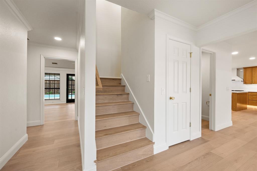 6403 Genstar Lane Dallas, TX 75252 - Photo 24 of 34 Hardwood staircase with natural wood treads and white risers, complemented by light wood-finish flooring throughout