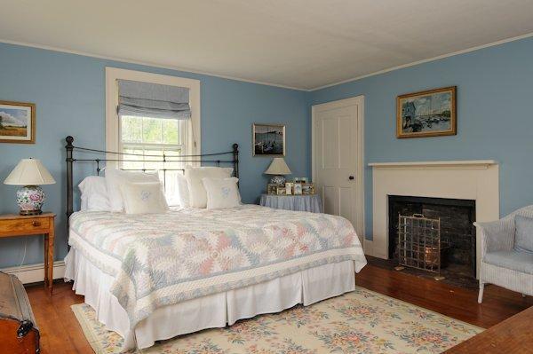 4084 Main Street Barnstable, MA 02675 - Photo 10 of 15 a large white bed in a bedroom and a fireplace
