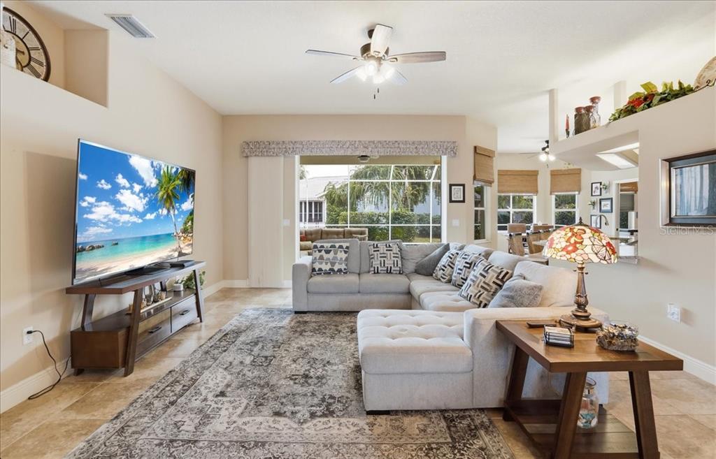 6710 Pleasant Hill Road Bradenton, FL 34203 - Photo 28 of 72 a living room with furniture a flat screen tv and a floor to ceiling window