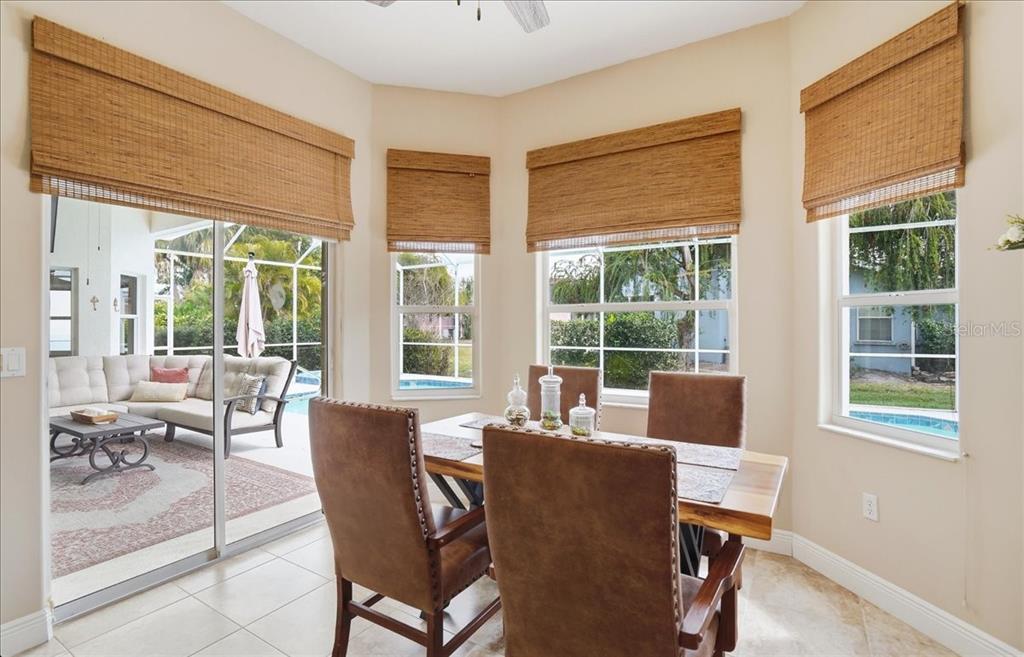 6710 Pleasant Hill Road Bradenton, FL 34203 - Photo 32 of 72 a view of a dining room with furniture large windows and wooden floor