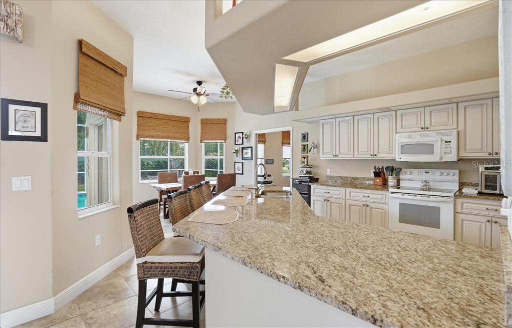 6710 Pleasant Hill Road Bradenton, FL 34203 - Photo 36 of 72 a large kitchen with kitchen island a large window in it and a dining table