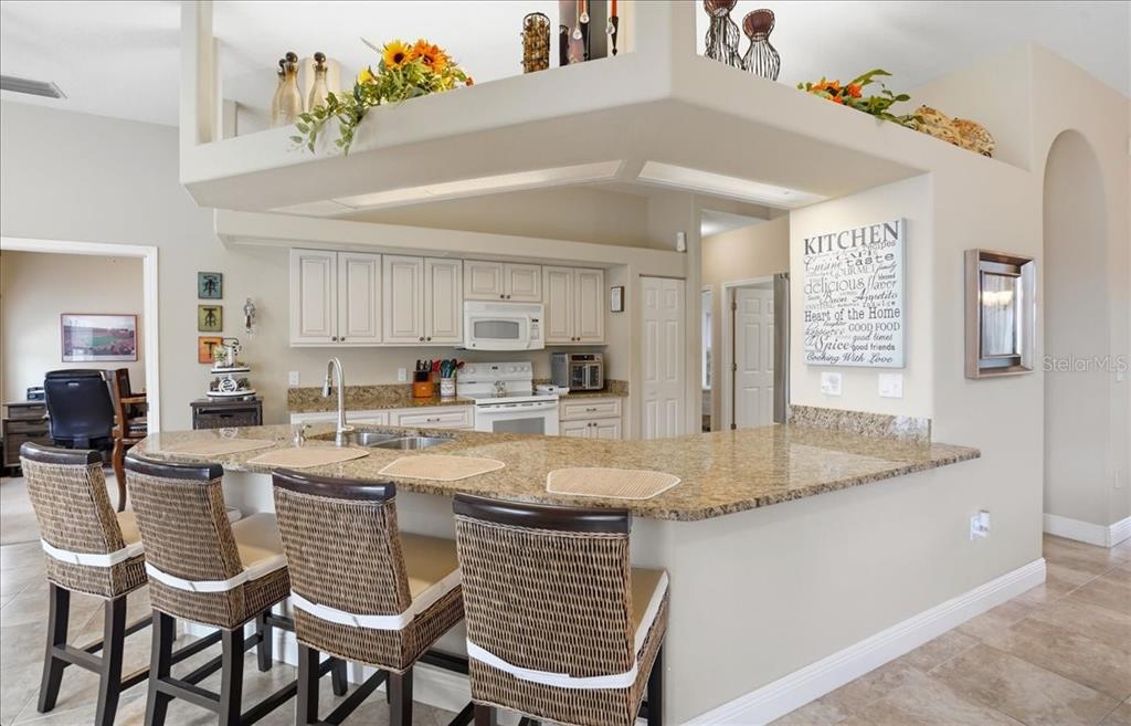 6710 Pleasant Hill Road Bradenton, FL 34203 - Photo 37 of 72 a kitchen with stainless steel appliances granite countertop a table chairs sink and cabinets