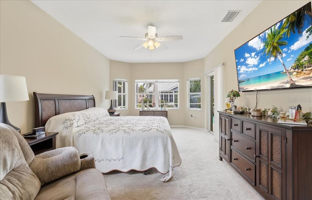 6710 Pleasant Hill Road Bradenton, FL 34203 - Photo 39 of 72 a spacious bedroom with a large bed and a chandelier