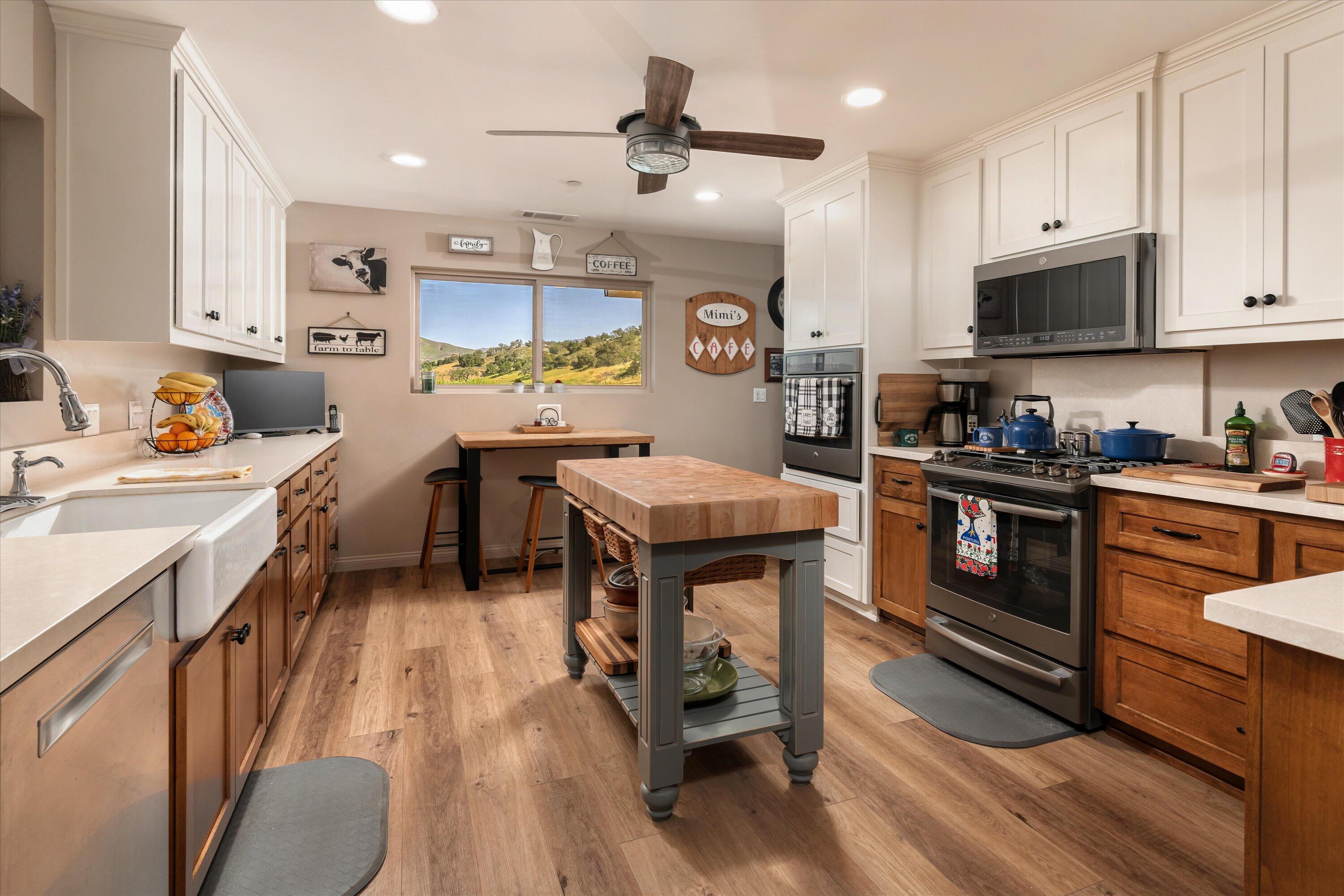 12707 Huasna Road Arroyo Grande, CA 93420 - Photo 37 of 77 a kitchen with stainless steel appliances granite countertop a stove top oven a sink dishwasher and white cabinets with wooden floor