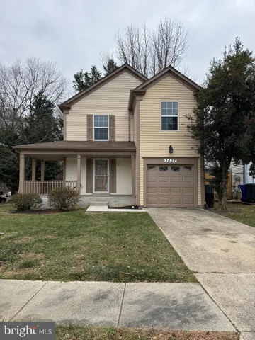 a view of a yard in front of a house with large windows
