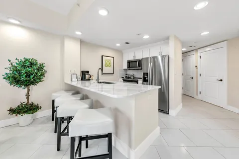 a kitchen with kitchen island a counter space cabinets and a refrigerator
