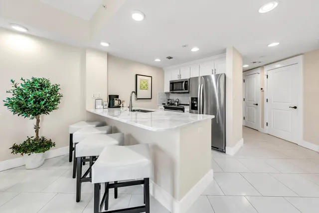 a kitchen with kitchen island a counter space cabinets and a refrigerator