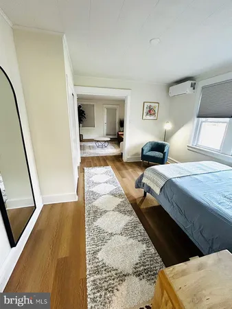 a bedroom with a bed and a dresser with mirror