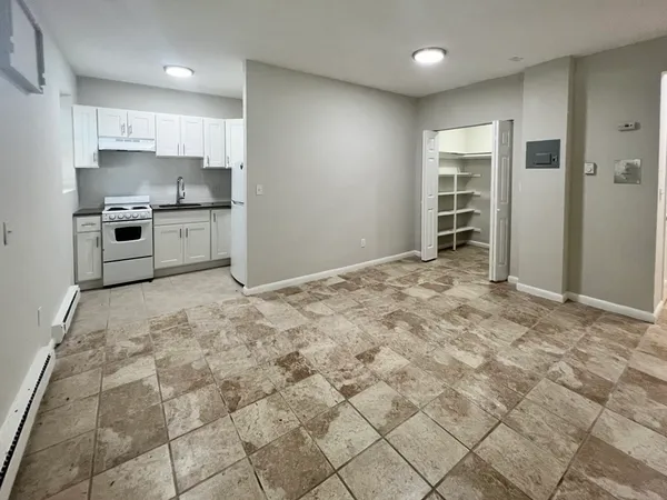 a kitchen with granite countertop a stove a sink and a refrigerator