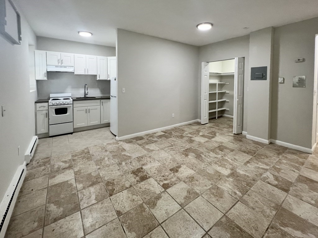 5 Beaver Park Road, Unit 1 Framingham, MA 01702 - Photo 2 of 4 a kitchen with granite countertop a stove a sink and a refrigerator