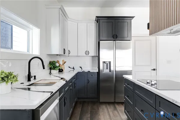 a kitchen with granite countertop a sink stainless steel appliances and window