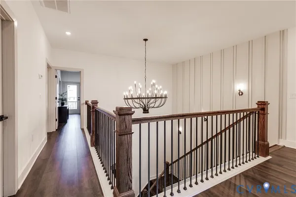 a view of a hallway with wooden floor and stairs