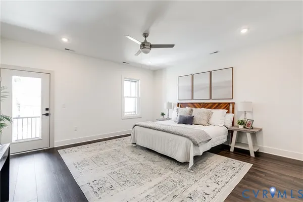 a bedroom with a large bed chandelier and a window