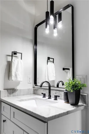 a bathroom with a sink a potted plant and a mirror