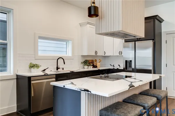 a kitchen with a sink a stove and chairs