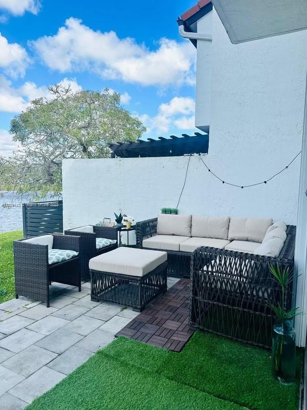 1351 Southwest 124th Court, Unit B5 Miami, FL 33184 - Photo 16 of 37 a view of a patio with couches table and chairs and potted plants