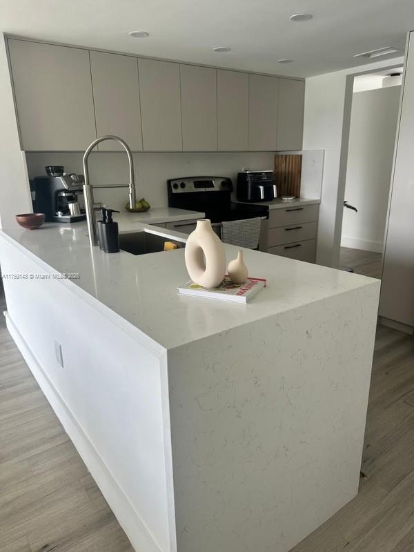1351 Southwest 124th Court, Unit B5 Miami, FL 33184 - Photo 10 of 37 a kitchen with stainless steel appliances a refrigerator a sink a stove and a wooden floors