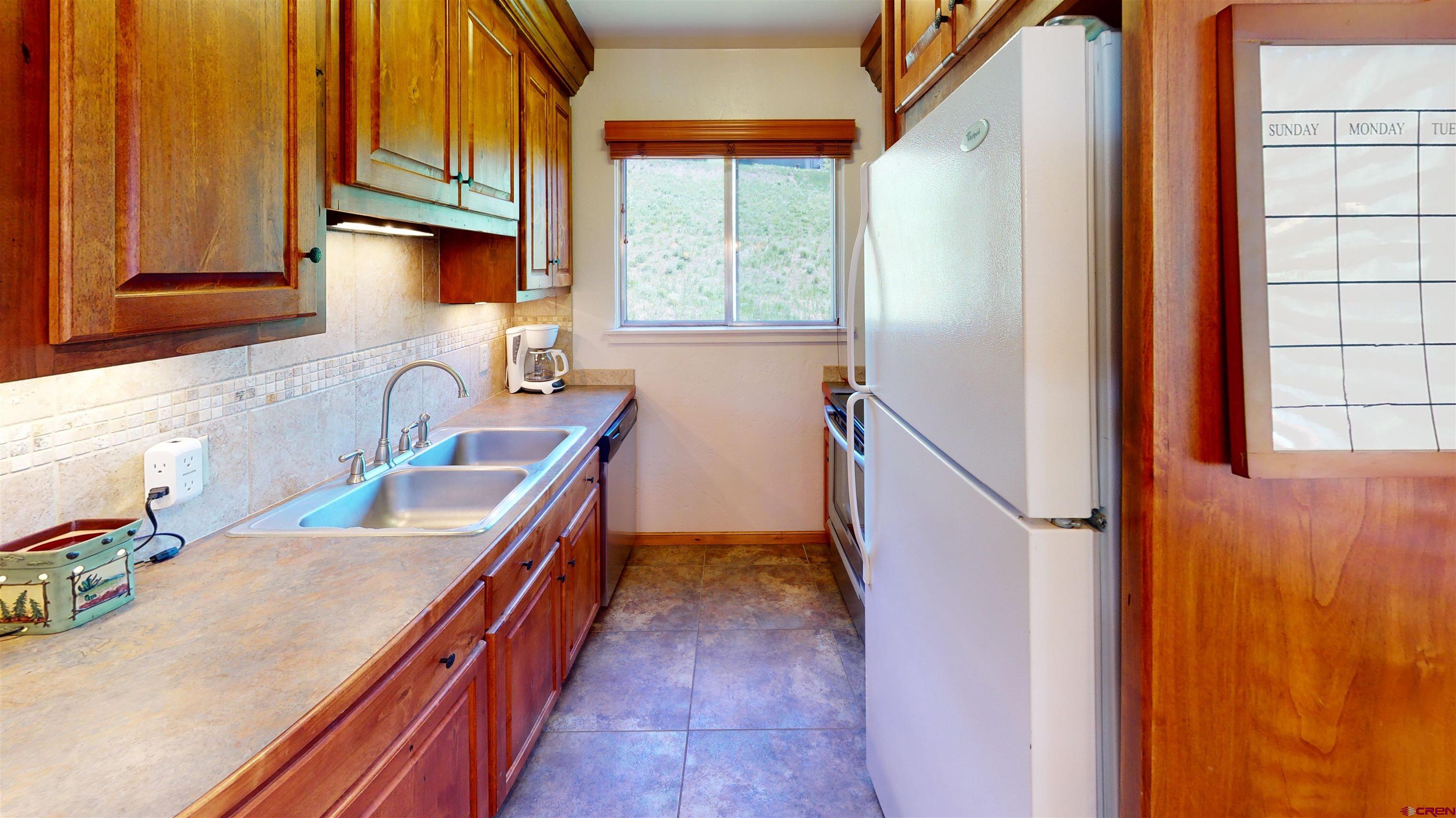 18 Crystal Road, Unit 3B Crested Butte, CO 81225 - Photo 9 of 20 a kitchen with blue cabinets and a large window
