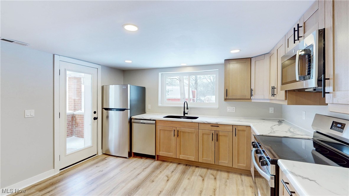2978 Long Road Uniontown, OH 44685 - Photo 14 of 40 Kitchen featuring appliances with stainless steel finishes, light wood finished floors, light stone countertops, and recessed lighting