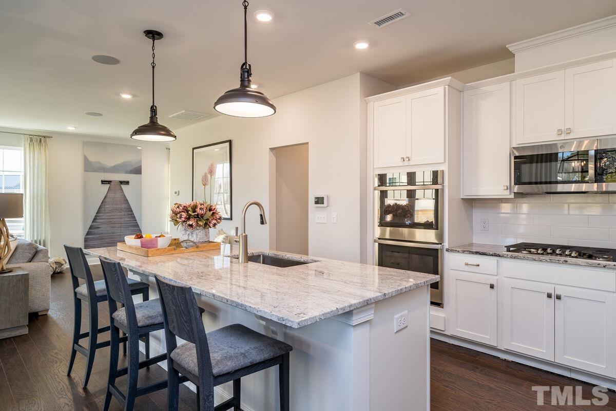 2201 Goudy Drive Raleigh, NC 27615 - Photo 15 of 24 a kitchen with stainless steel appliances granite countertop a dining table chairs stove a refrigerator and microwave