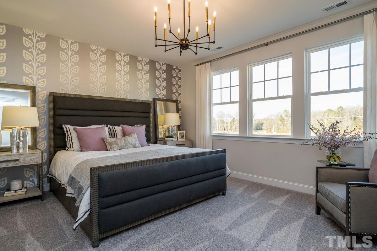 2201 Goudy Drive Raleigh, NC 27615 - Photo 18 of 24 a bedroom with a bed a chandelier and a window