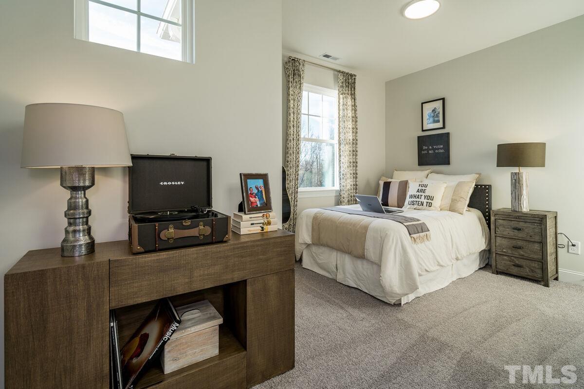 2201 Goudy Drive Raleigh, NC 27615 - Photo 22 of 24 a bedroom with a bed a couch and a flat tv screen on the dresser