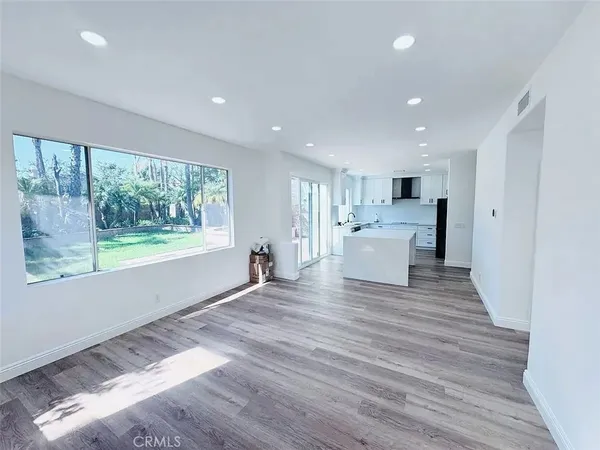 a view of a living room a kitchen and a wooden floor