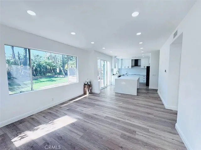 a view of a living room a kitchen and a wooden floor