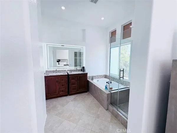 a bathroom with a tub sink and mirror