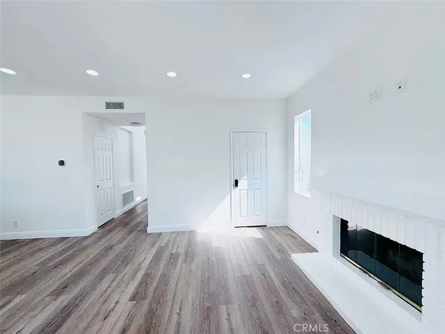 a view of a room with wooden floor and fireplace