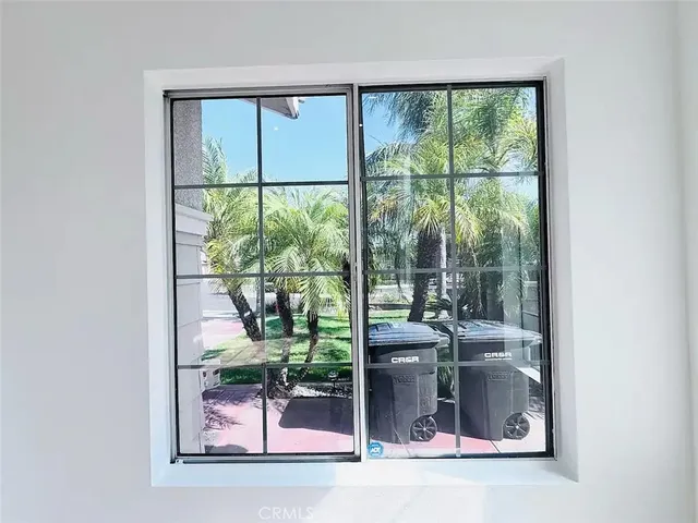 a room with a floor to ceiling window and a lake view