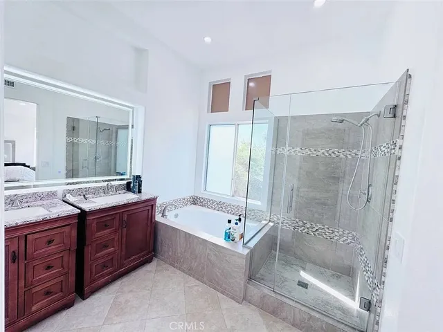 a bathroom with a tub sink shower and mirror