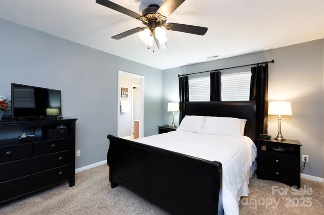 a bedroom with a bed and a flat tv screen on dresser