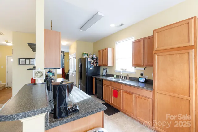 a kitchen with stainless steel appliances granite countertop a sink refrigerator and cabinets