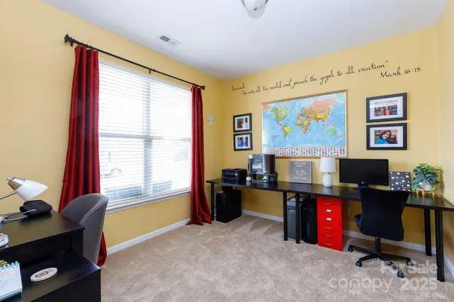 a view of a workspace with furniture and a window