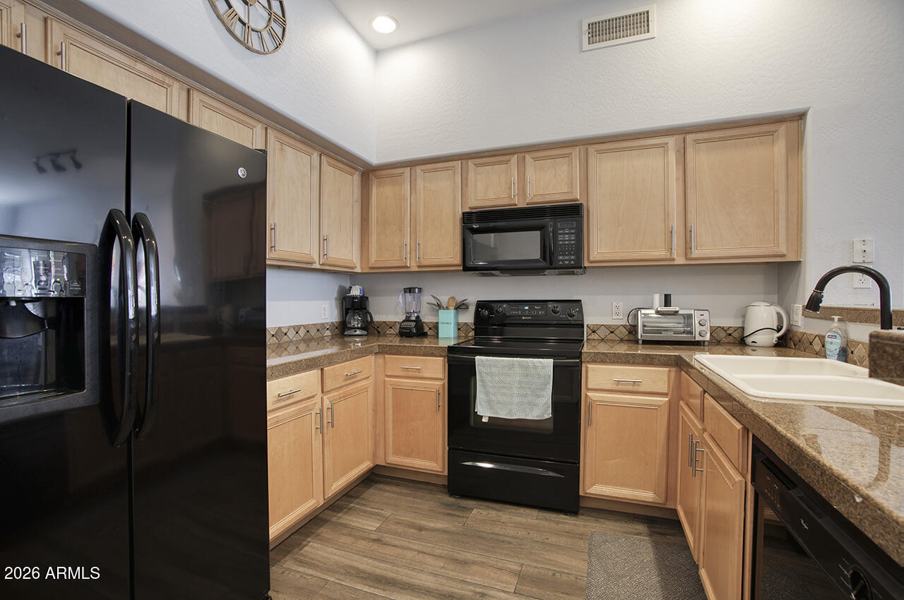 2989 North 44th Street, Unit 1024 Phoenix, AZ 85018 - Photo 3 of 16 a kitchen with granite countertop a refrigerator stove and sink