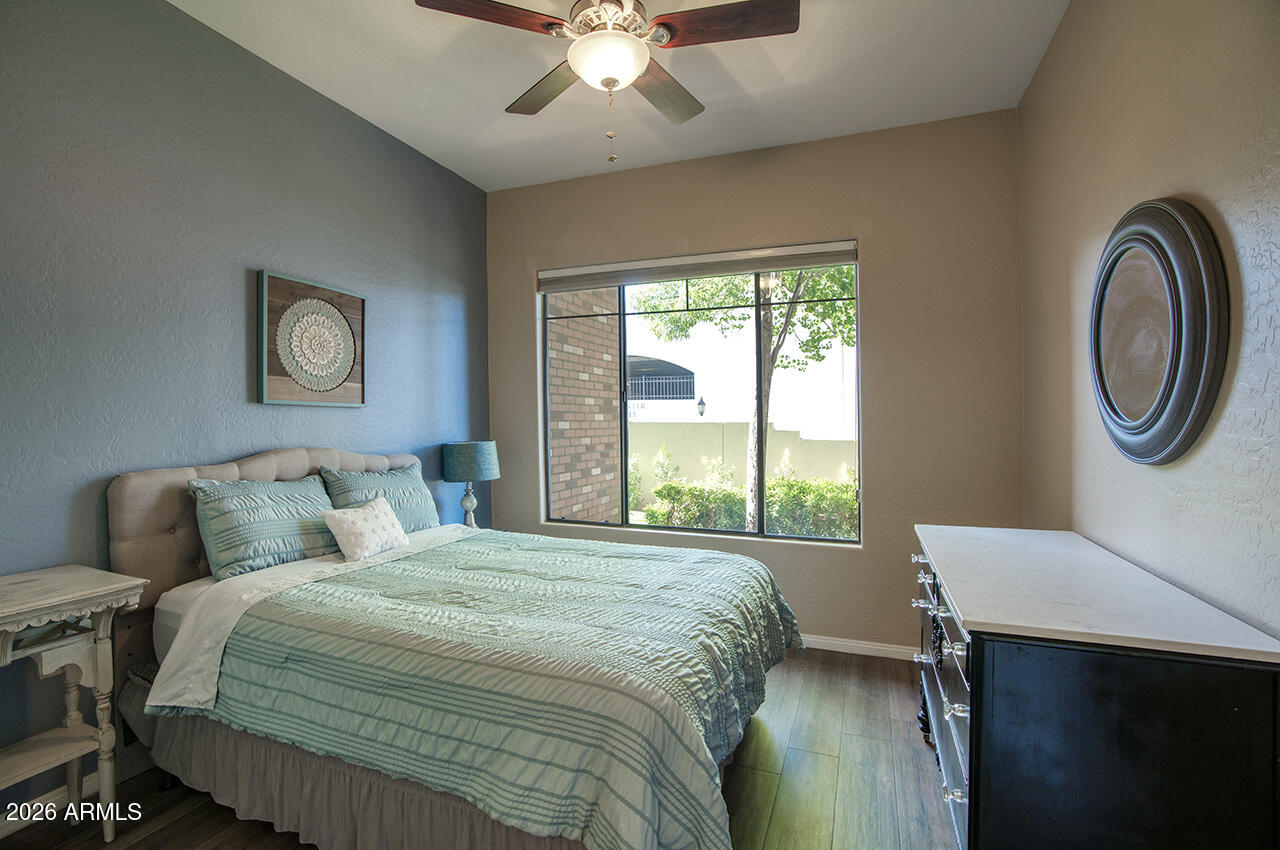 2989 North 44th Street, Unit 1024 Phoenix, AZ 85018 - Photo 9 of 16 a bedroom with a bed and a table with lamp