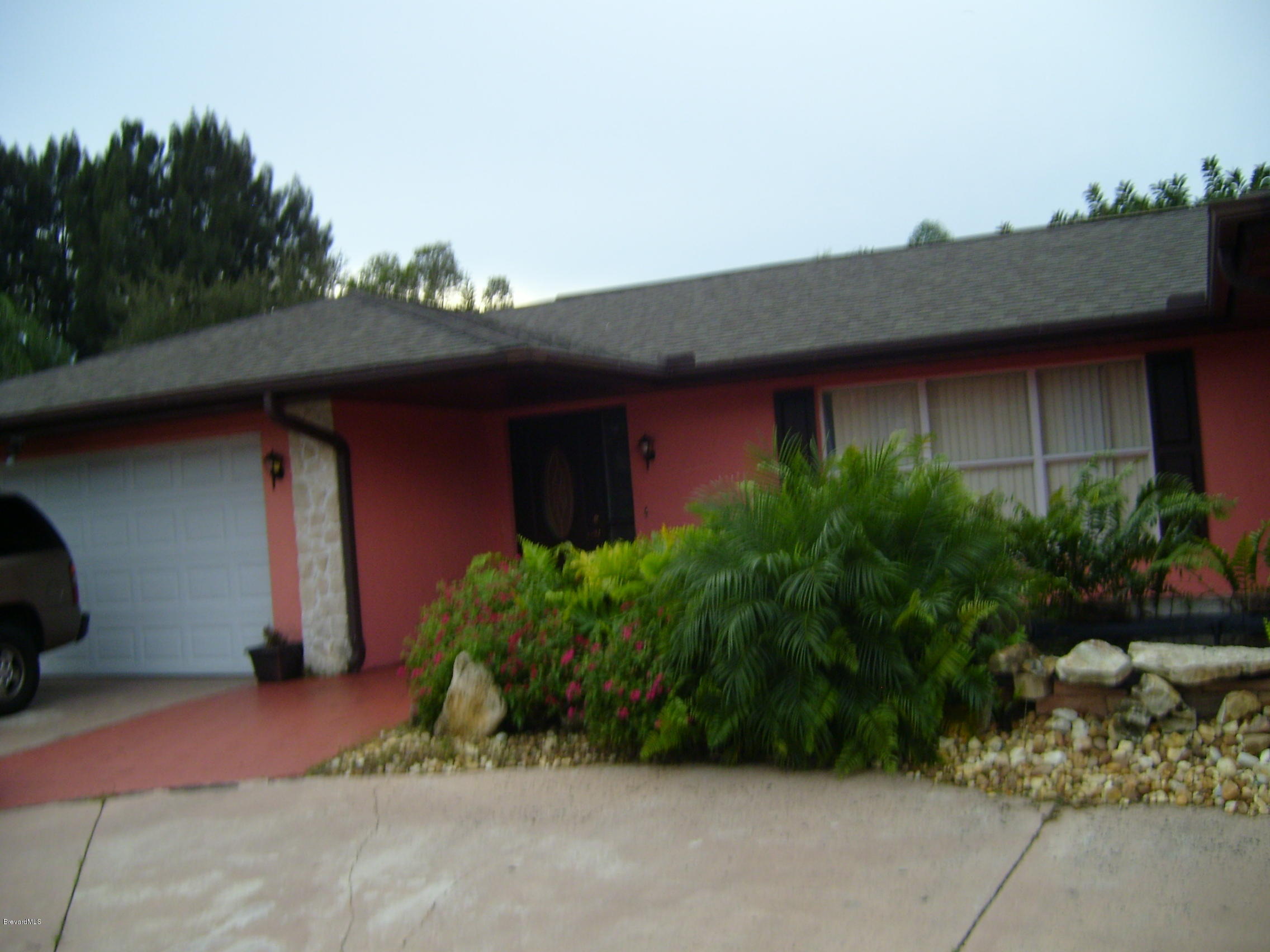 1474 Meadowbrook Road Northeast, Unit NE Palm Bay, FL 32905 - Photo 1 of 24 a front view of house with garden