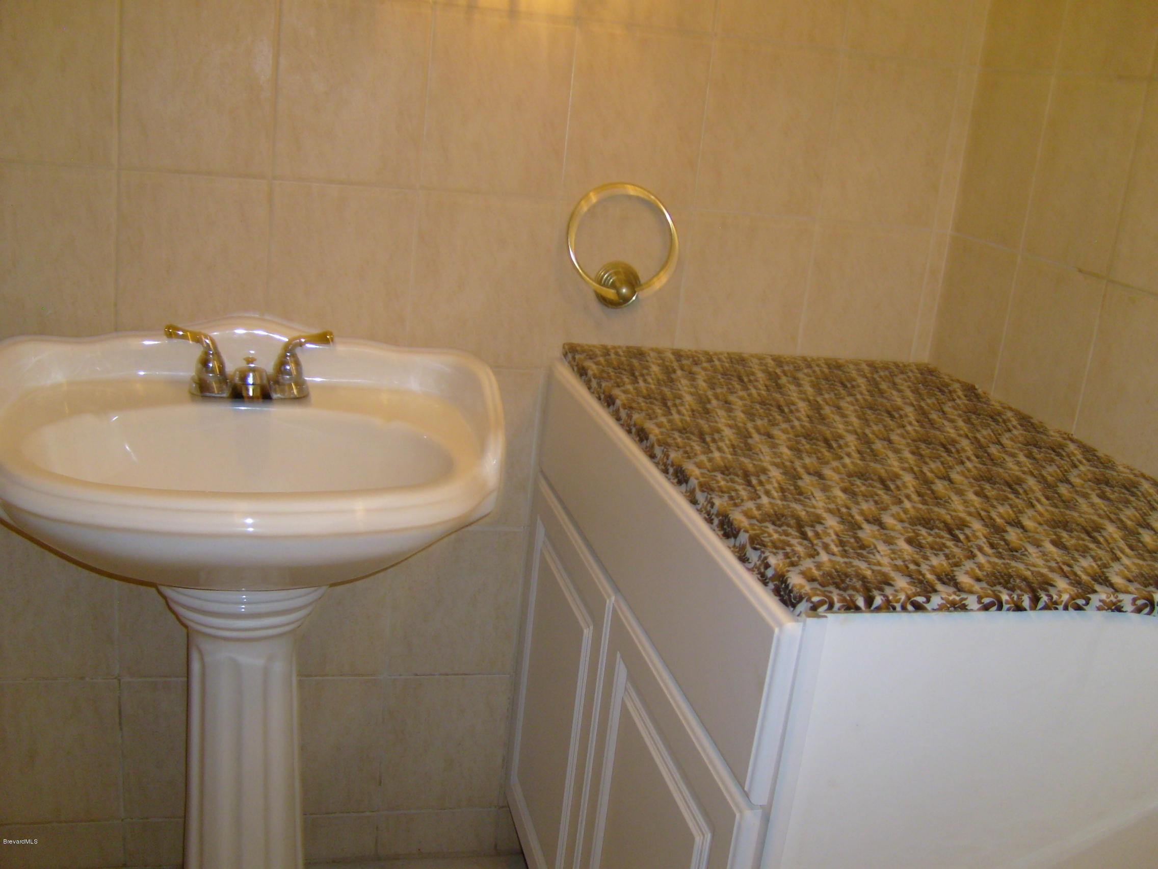 1474 Meadowbrook Road Northeast, Unit NE Palm Bay, FL 32905 - Photo 18 of 24 a bathroom with a sink and a mirror