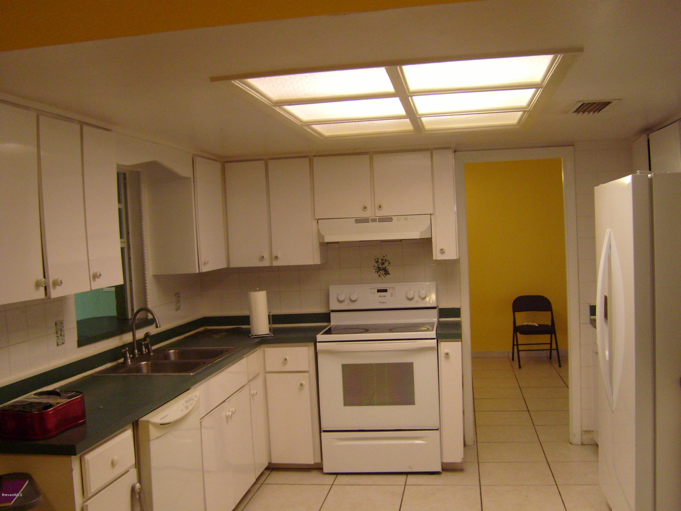 1474 Meadowbrook Road Northeast, Unit NE Palm Bay, FL 32905 - Photo 8 of 24 a kitchen with a stove a sink and a refrigerator