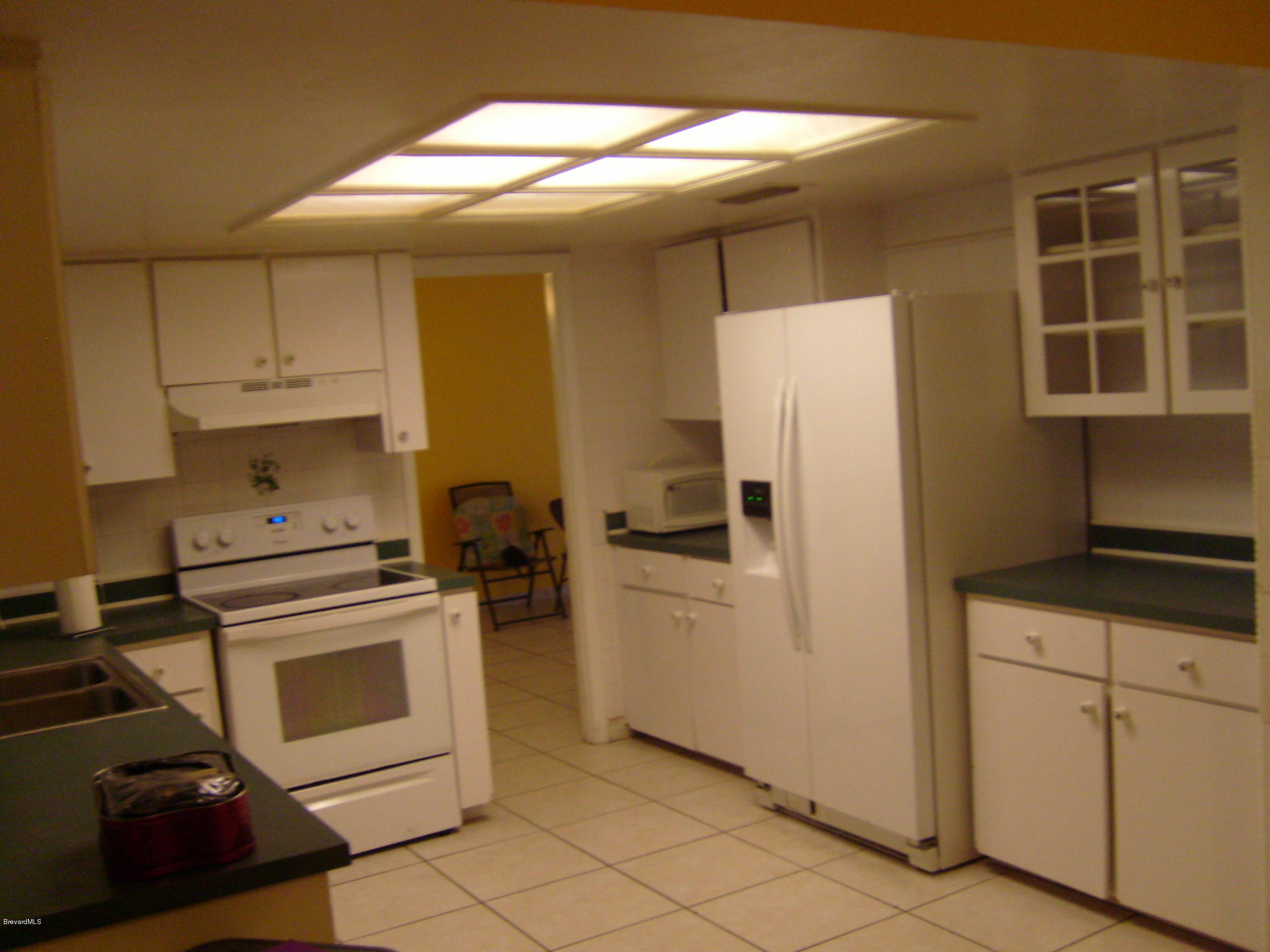 1474 Meadowbrook Road Northeast, Unit NE Palm Bay, FL 32905 - Photo 9 of 24 a kitchen with white cabinets and white appliances