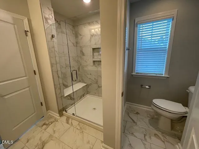 a bathroom with a granite countertop shower and a toilet